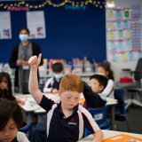 child putting his hand up