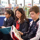 three students reading books