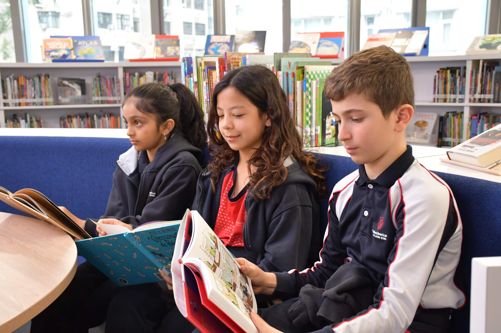 three students reading books