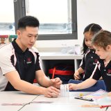 teacher helping students with experiment