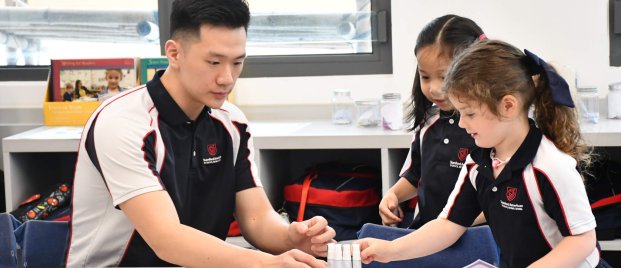 teacher helping students with experiment